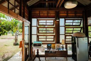 a room with windows and a refrigerator in a house at Shine Villa Sukhothai in Sukhothai