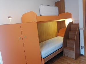 a bunk bed in a room with a desk and a bed at Casa Fabiola in Longarone