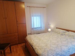 a bedroom with a bed and a dresser and a window at Casa Fabiola in Longarone