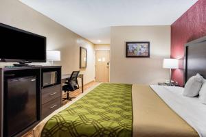 a hotel room with a bed and a flat screen tv at Econo Lodge Painted Post - Corning in Painted Post