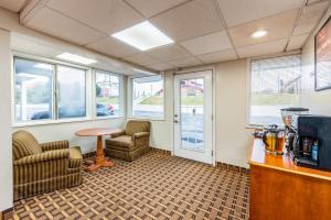 a waiting room with chairs and a table and windows at Econo Lodge Franklin - Springboro in Franklin