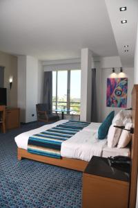 a hotel room with a large bed and a large window at Bel Azur Hotel - Resort in Jounieh +7 photos