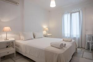 a white bedroom with a large bed with towels on it at Aeraki Villas in Santa Maria
