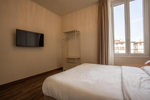 a bedroom with a bed and a tv on the wall at Lumi Stays in Florence