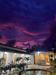 a night view of a building with a swimming pool at Jancoox Hostel in Kuta Lombok