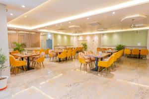a dining room with tables and yellow chairs at Hotel Annapurna The Luxurious in Nalanda