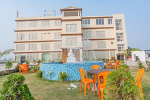 a table and chairs in front of a building with a fountain at Hotel Annapurna The Luxurious in Nalanda