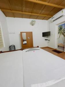 a living room with a bed and a television at RiverSoul Pool Villa in North Paravur