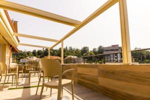 a balcony with chairs and tables on a building at Hotel Pandora Residence in Tirana