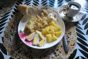 a plate of food with eggs and potatoes on a table at Chez Fatou et Saladin in Diana