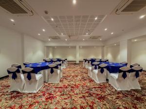 a room with blue and white tables and chairs at Zip By Spree Hotels Ranjangaon in Ranjangaon Ganpati