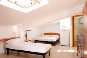 una camera da letto con due letti e un lucernario di Residence Devi a Mandatoriccio Marina