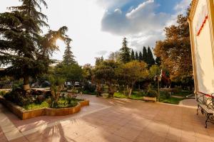 a courtyard with benches and trees in a park at El hotel in Ganja