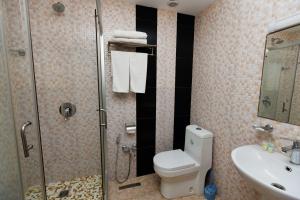 a bathroom with a shower and a toilet and a sink at El hotel in Ganja +14 photos