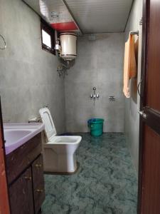 a bathroom with a white toilet and a sink at Paradise Homestay Tosh in Tosh