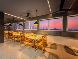 a dining room with tables and chairs and windows at Zip By Spree Hotels Ranjangaon in Ranjangaon Ganpati
