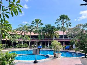 a resort with a swimming pool and palm trees at Pangkor Sandy Beach Resort in Pangkor