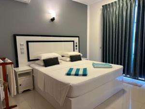 a bedroom with a large white bed with a window at Riveli Retreat Mathiveri in Mathiveri