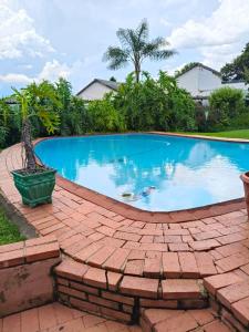 a large swimming pool on a brick patio at Loema-in in Roodepoort