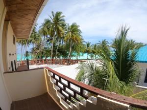 a balcony with a view of the beach and palm trees at Riveli Retreat Mathiveri in Mathiveri