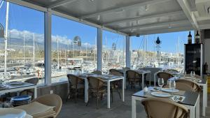 a restaurant with tables and chairs and a view of a marina at Velero Passionetenerife in San Miguel de Abona