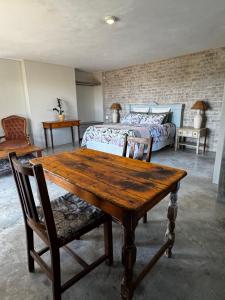 a bedroom with a wooden table and a bed at Fraai Brak in Klein-Brakrivier