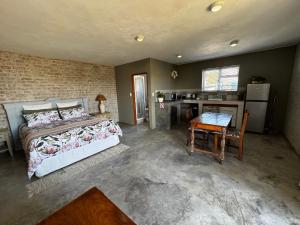 a bedroom with a bed and a table and a kitchen at Fraai Brak in Klein-Brakrivier