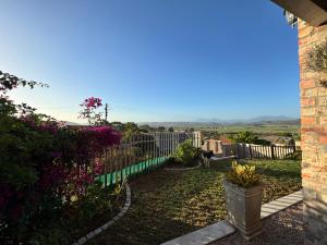 a view of a yard with a fence and flowers at Fraai Brak in Klein-Brakrivier