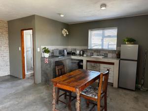 a kitchen with a wooden table and a refrigerator at Fraai Brak in Klein-Brakrivier +1 photo