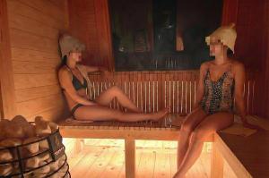 two women sitting on a bench in a sauna at スターハウス in Otsu
