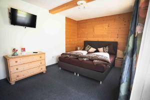 a bedroom with a bed and a dresser at HAUS Lampacher in Ganda di Martello