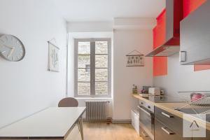 a kitchen with a table and a clock on the wall at L'Historique in Rennes