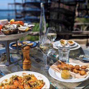 a table with plates of food and glasses of wine at Le Bateau du Canal Sète in La Celle-sous-Gouzon
