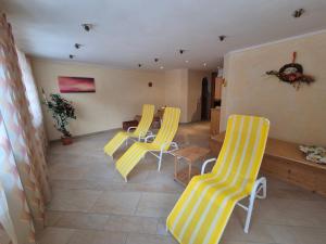 a room with four yellow chairs and a table at Pfandlinghof in Grossarl