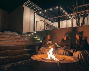 a group of people sitting around a fire at スターハウス in Otsu +55 photos