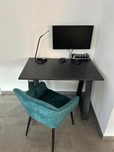 a desk with a computer monitor and a blue chair at Arche Otto in Marienheide