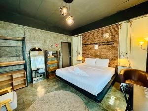 a bedroom with a bed and a brick wall at Tanwa House in Chiang Mai