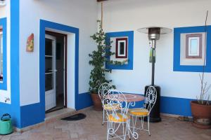 a patio with a table and chairs and a blue wall at Herdade Alem Santos in Lousal