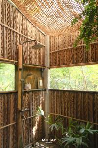 a room with a wooden wall with windows at MOCAY farmstay in Ben Tre