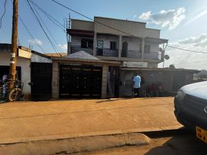 a man standing in front of a house at Petit Nid Douillet à Etoudi in Yaoundé