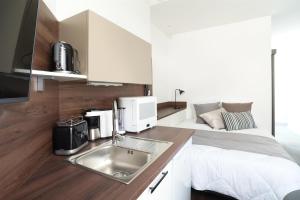 a kitchen with a sink and a bed in a room at Les cles du 27 Paris in Paris