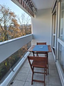 a balcony with a table and two chairs on it at Appartement T3 GEO ANDRE in Lormont