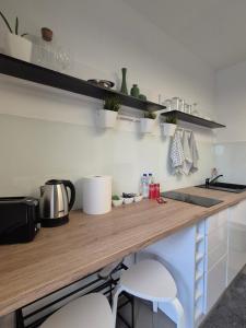 a kitchen with a wooden counter top with two stools at Studio Apartman 47B in Valjevo +4 photos