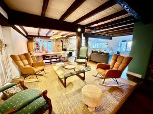 a living room with couches and chairs and a table at Le Gîte de Hildegarde in Granges-Aumontzey