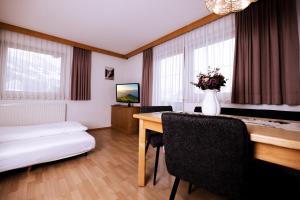 a room with a desk and a bed and a table with flowers at Appartement Susanna in Fügen