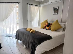a bedroom with a bed with two stuffed animals on it at Ceelee's Place in Bloemfontein