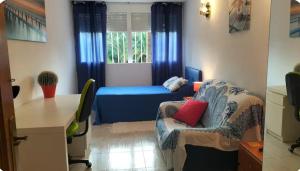 a small room with a blue bed and a desk at Habitación individual en la playa in Alicante
