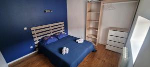 a bedroom with a blue bed with white towels on it at Le Duplex in Coligny