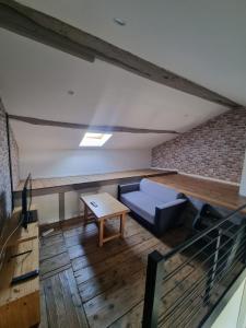 an attic room with a couch and a table at Le Duplex in Coligny