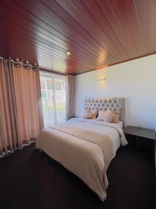 a bedroom with a large bed with a large window at Blackpool Hub in Nikawatawana